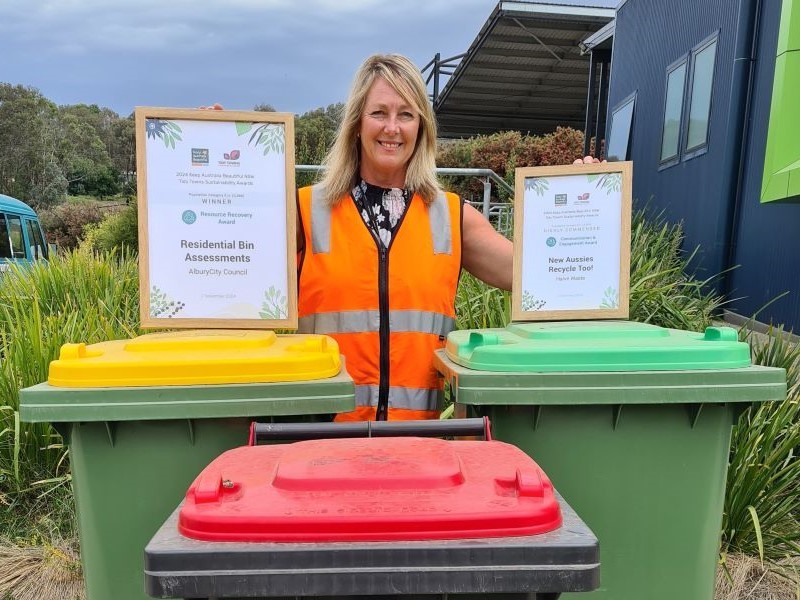 woman holding certificates with bins