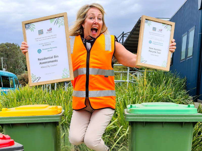 Woman jumping for joy holding two certificates