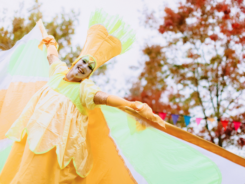 A stilt walker performing at Riverside Vibes wearing a yellow butterfly costume