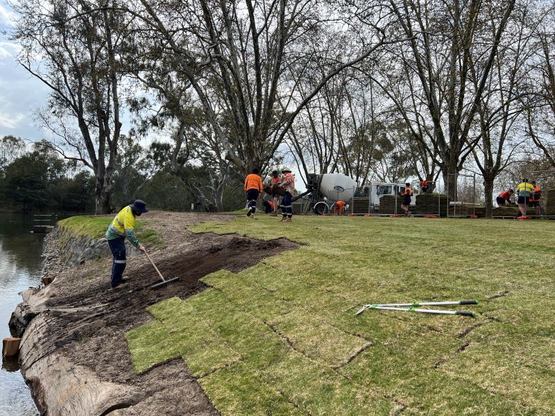 Man raking soil near river