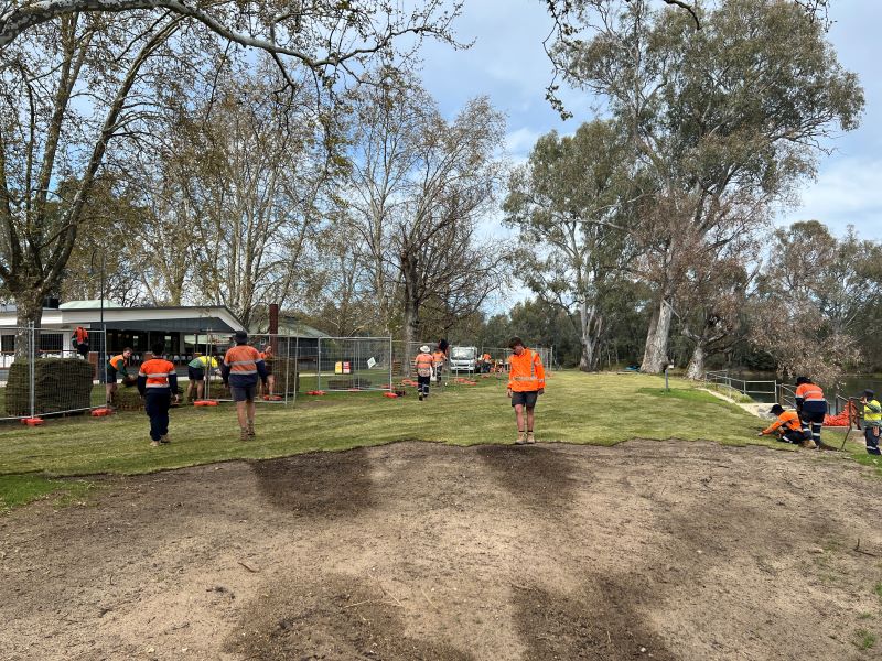 People carrying and laying turf