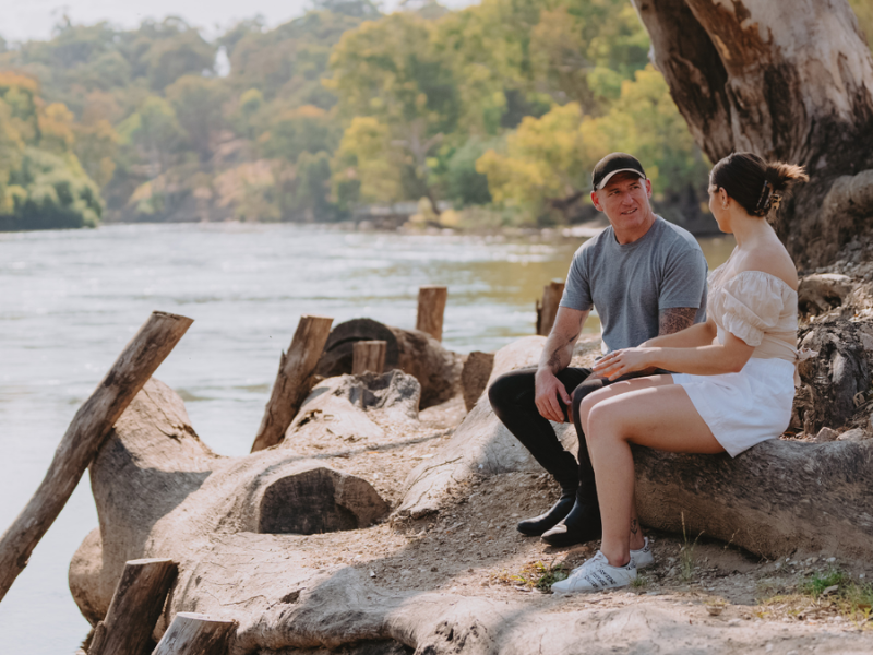 Two people sitting by the Murray River